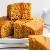 A stack of gluten free cornbread slices with honey dripping down.