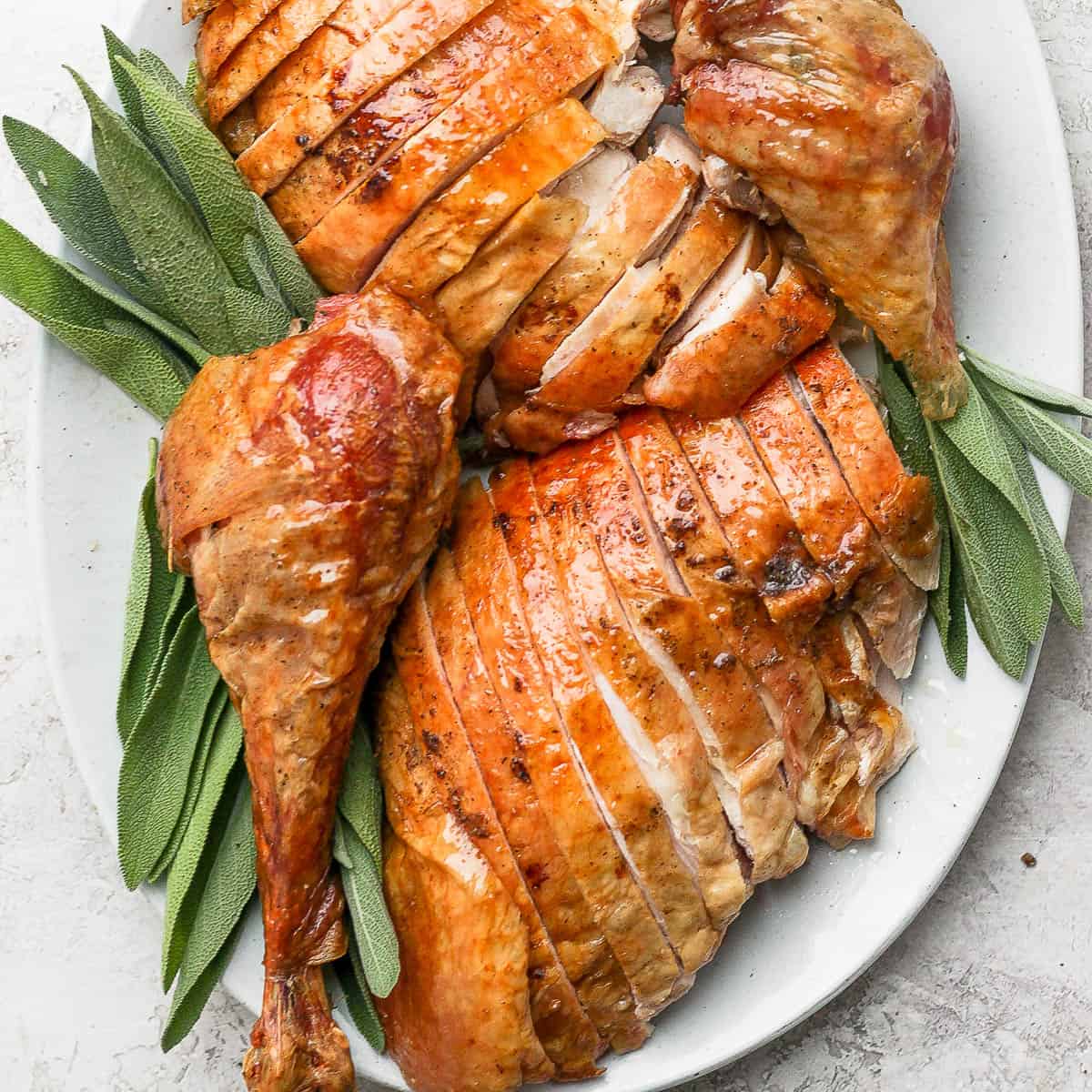 Plate of a whole smoked turkey carved and sliced.