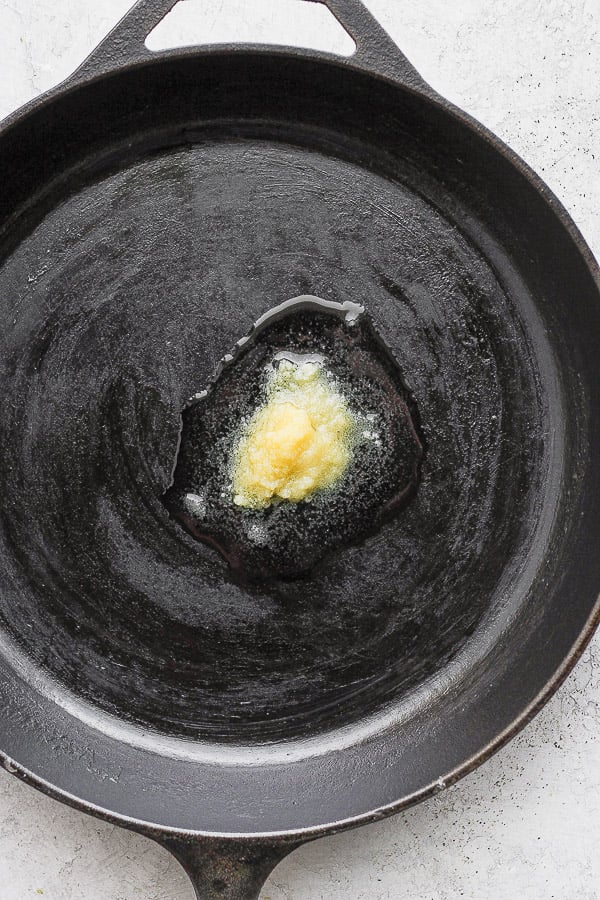 Cast iron skillet with melting ghee in the middle. 