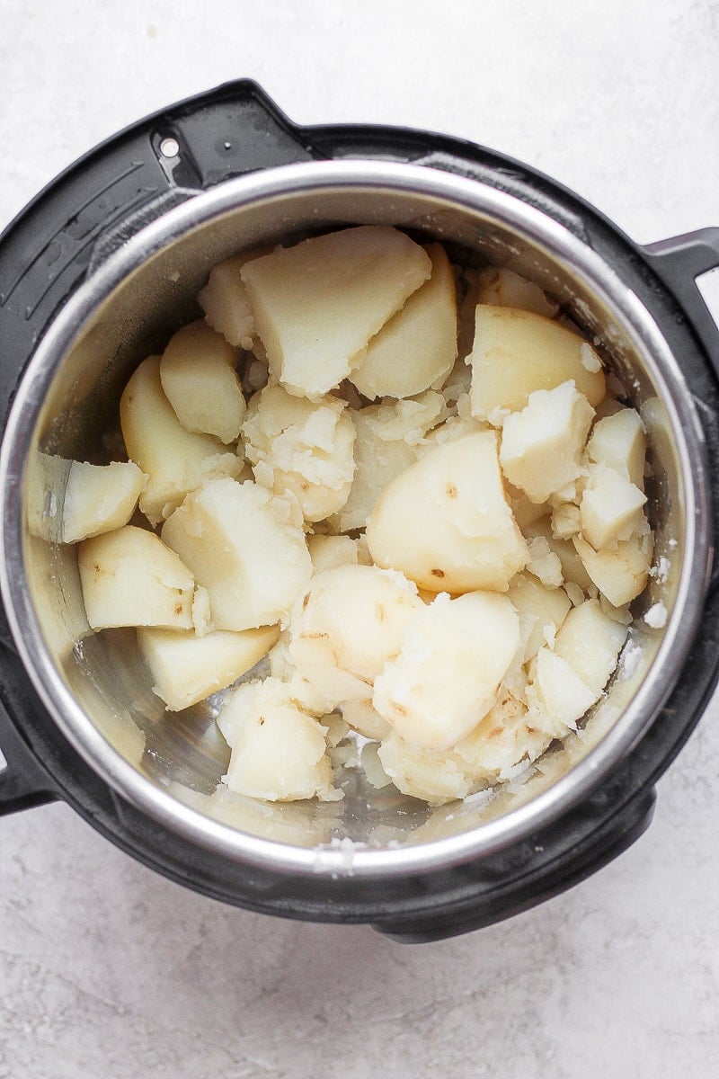 An Instant Pot with chunks of cooked potatoes that have been drained and returned to the Instant Pot.