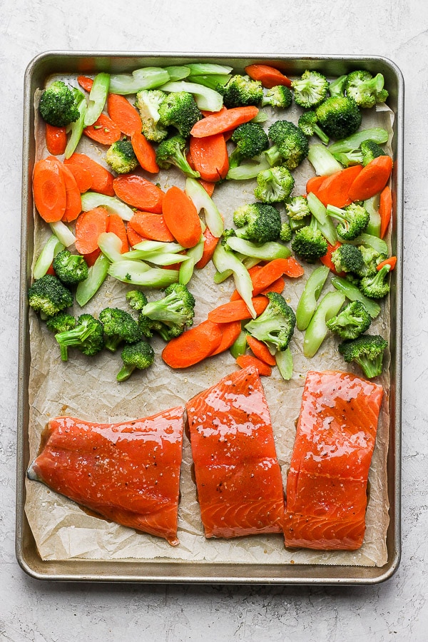 Vegetables and teriyaki salmon on the baking sheet.