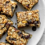 Several trail mix bars on a white plate.