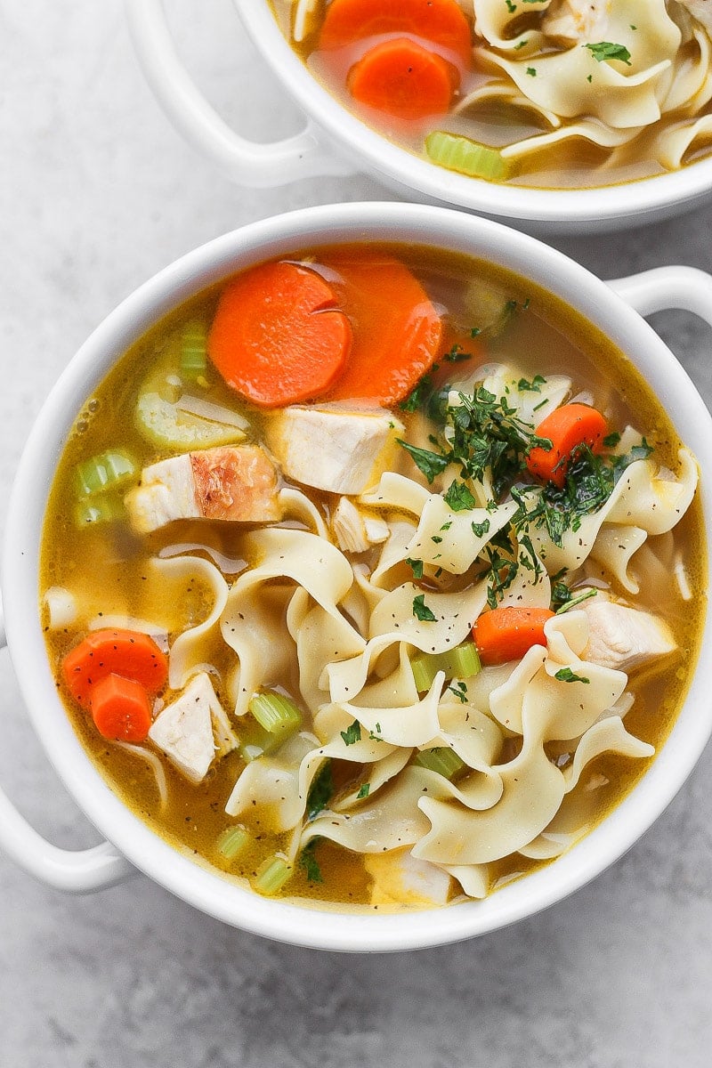 A white bowl with homemade turkey noodle soup.