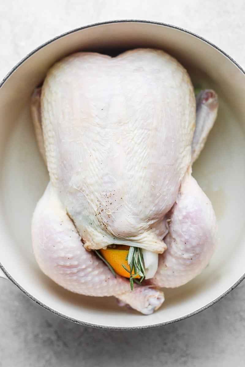 Raw whole chicken in a dutch oven. 