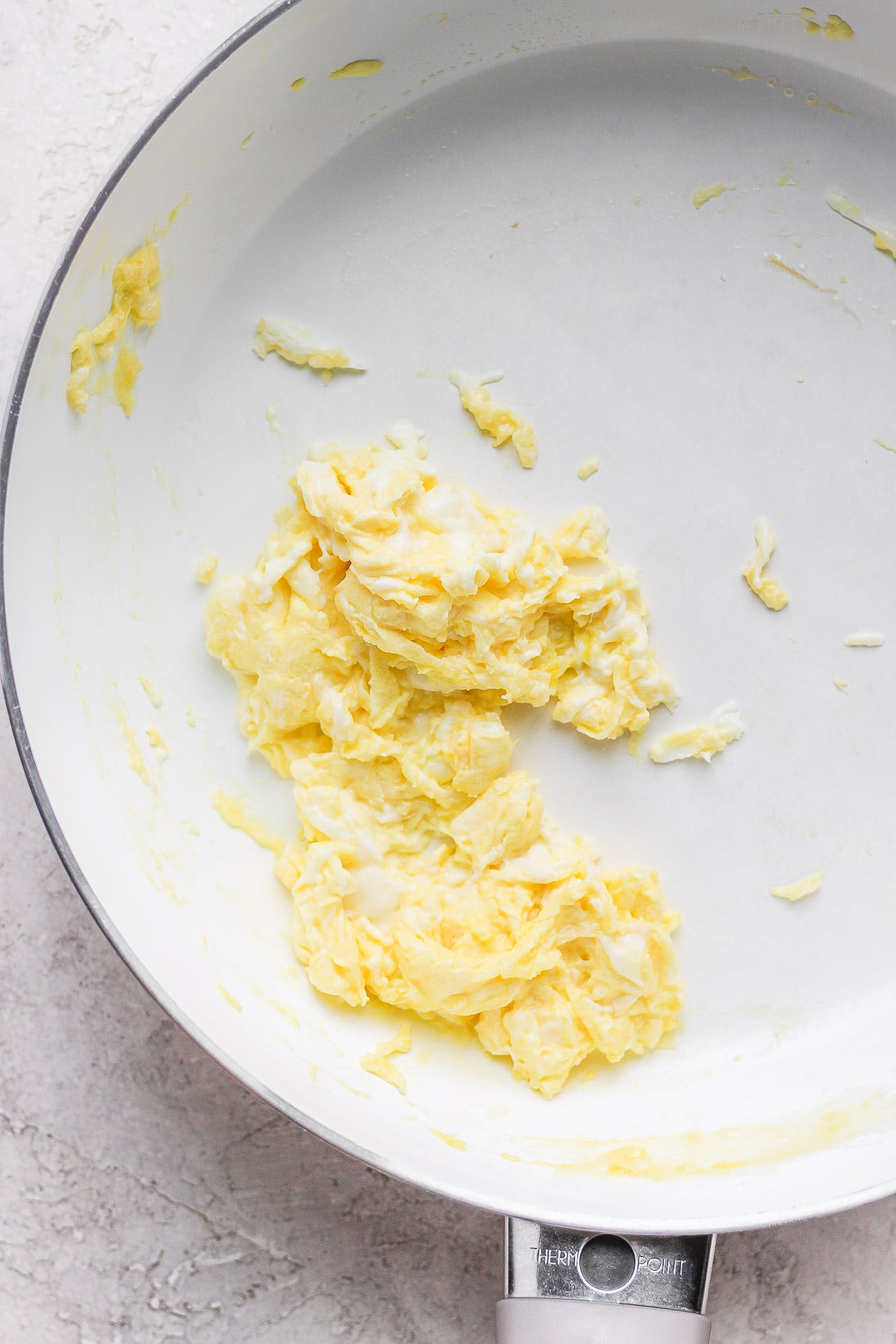 Scrambled eggs in a white pan. 