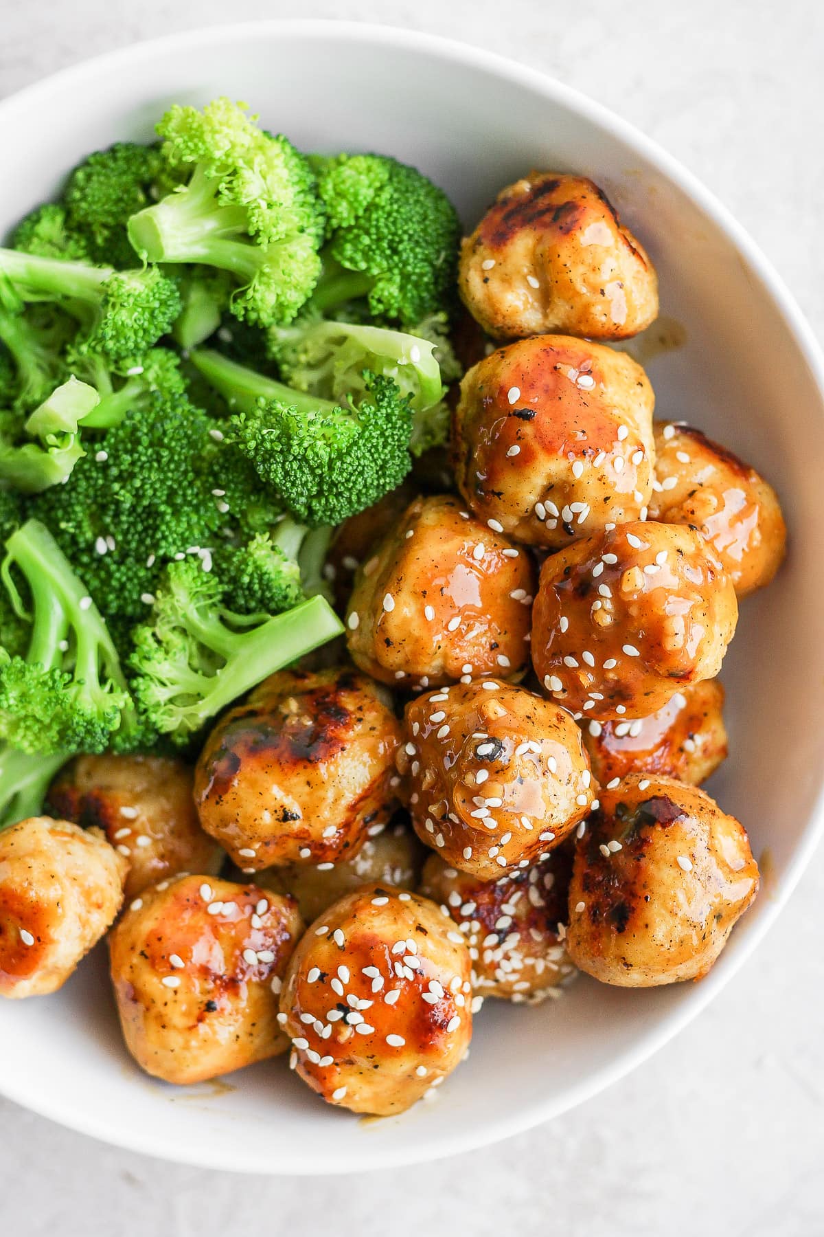 Bowl of orange chicken meatballs with broccoli. 