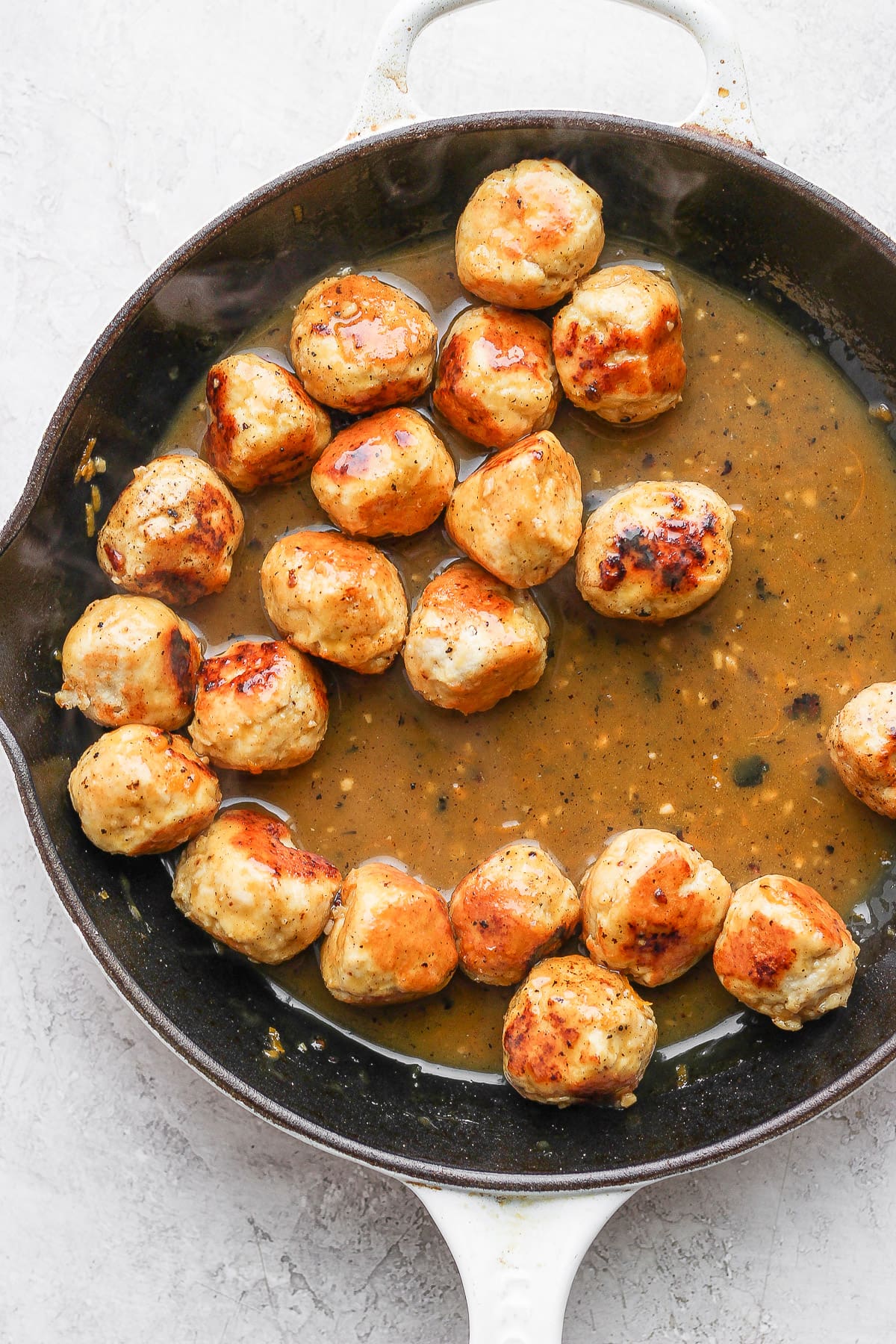 Skillet of orange chicken meatballs with the sauce. 