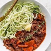 Beef ragu with zoodles in a white bowl.