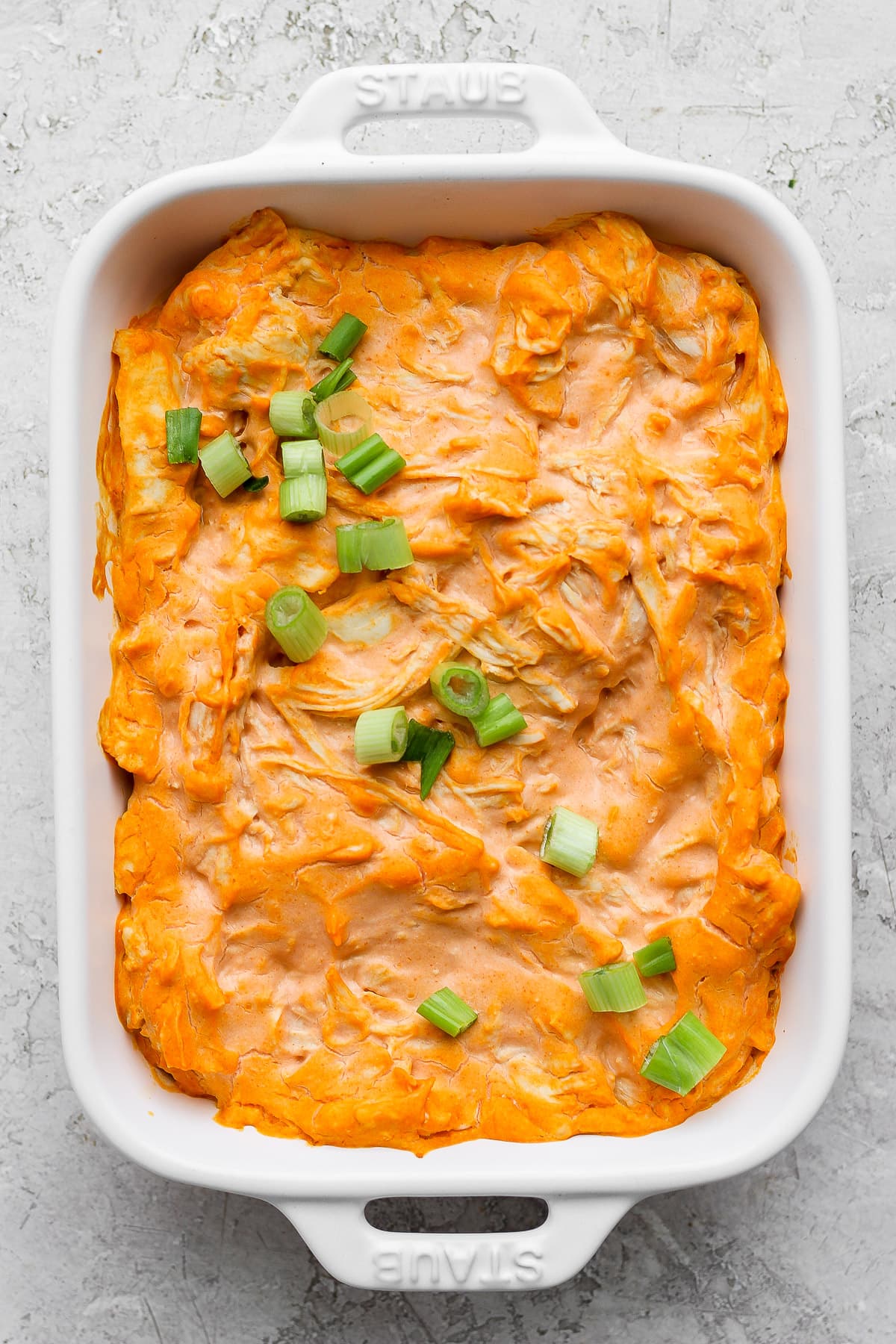 Baking dish with cooked healthy buffalo chicken dip. 