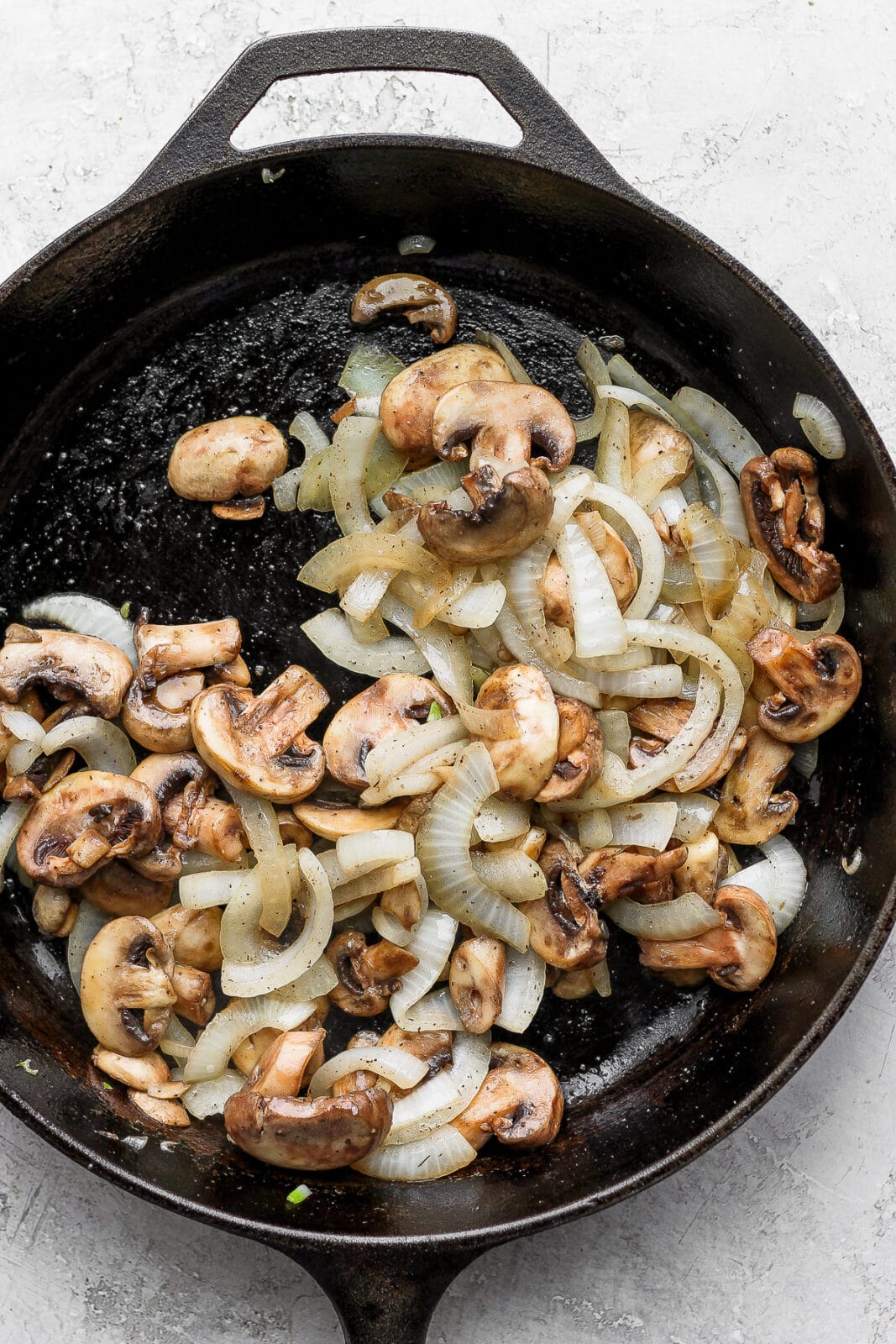 Cast iron pan with sautéed onions and mushrooms.