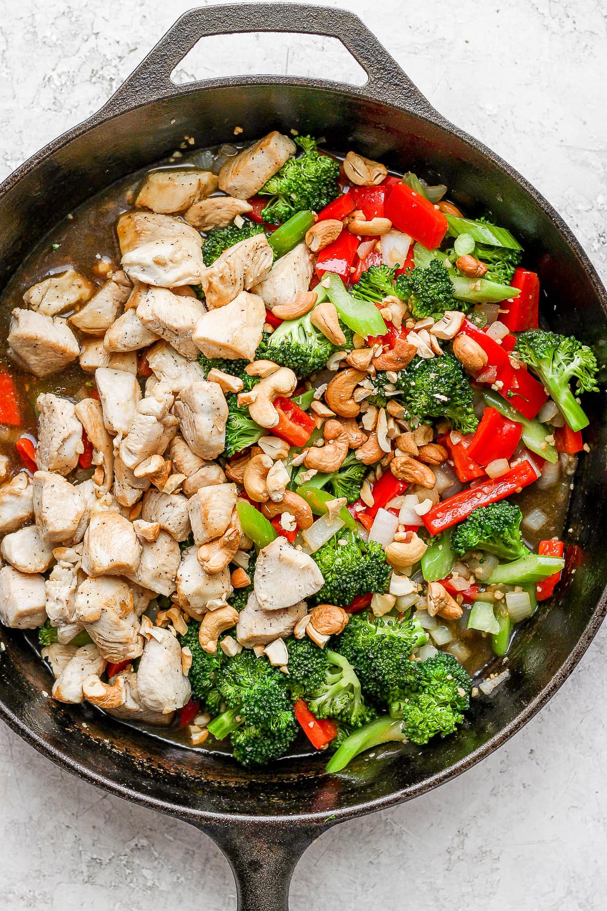 Cast iron pan with cooked cashew chicken stir fry.