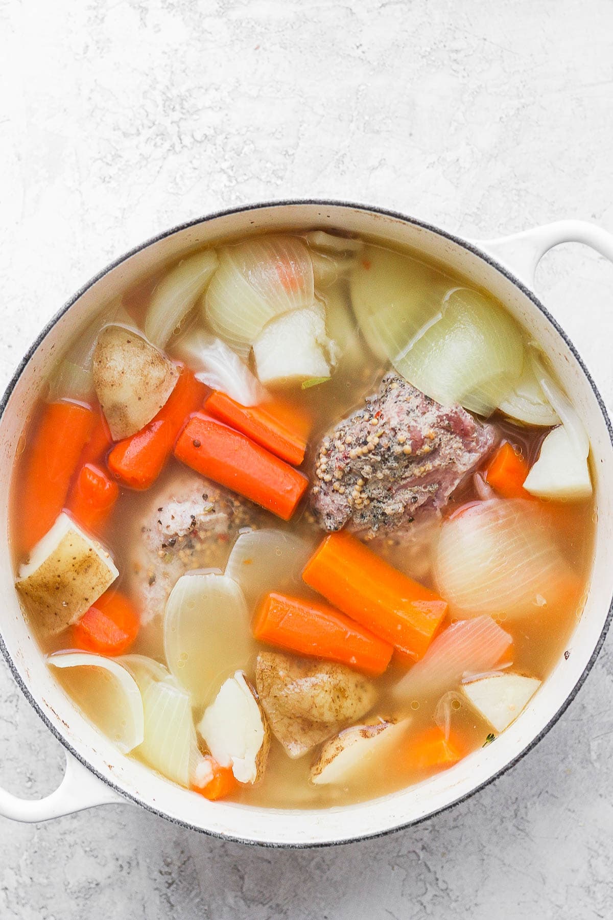 Dutch oven filled with a cooked corned beef and veggies. 