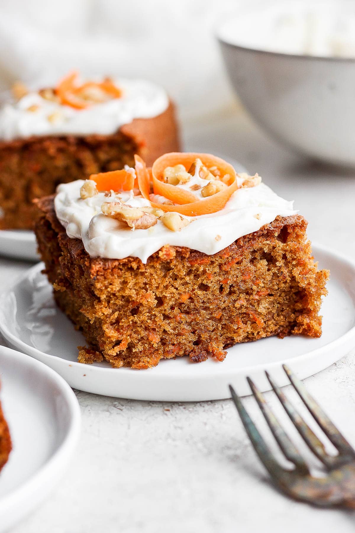 Plate with a slice of gluten free carrot cake with cream cheese frosting.