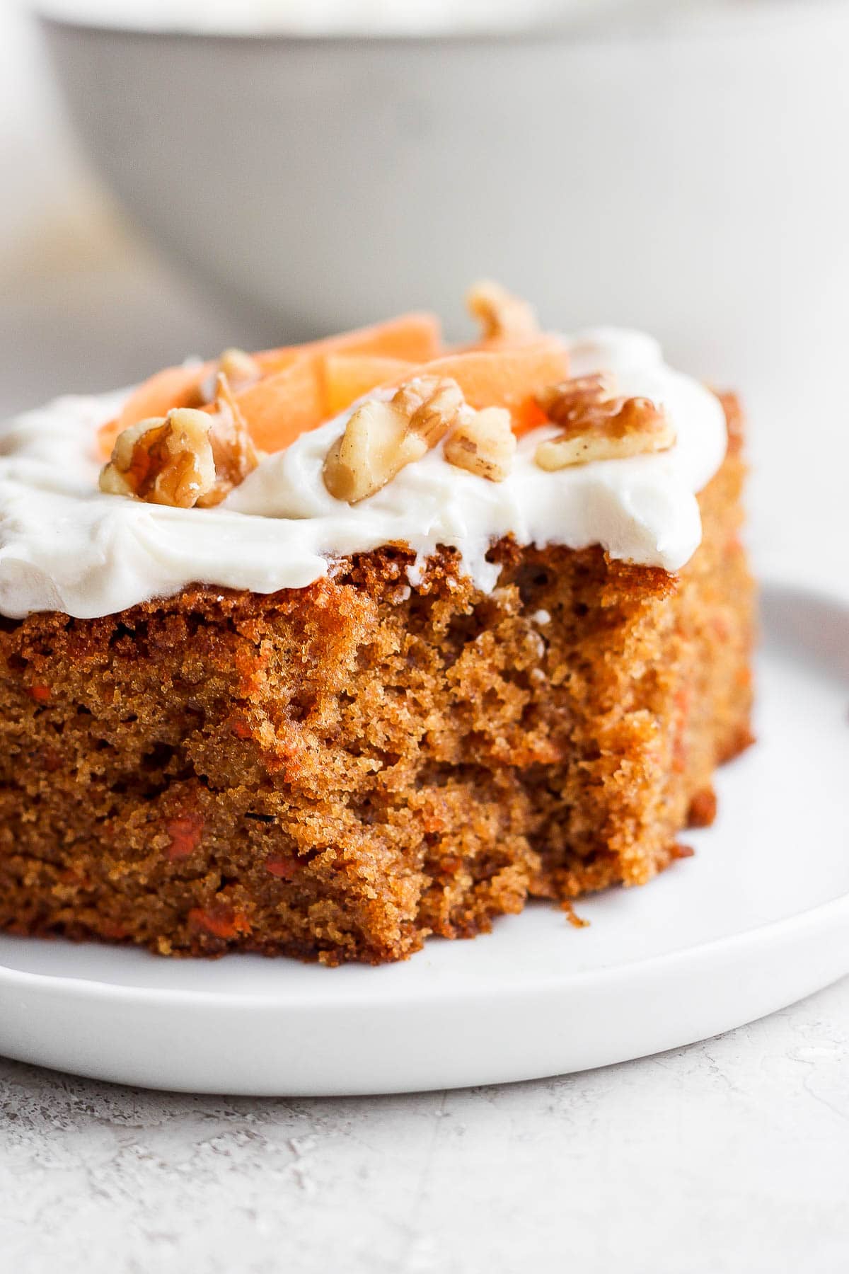 Slice of gluten free carrot cake with a bite out of it.