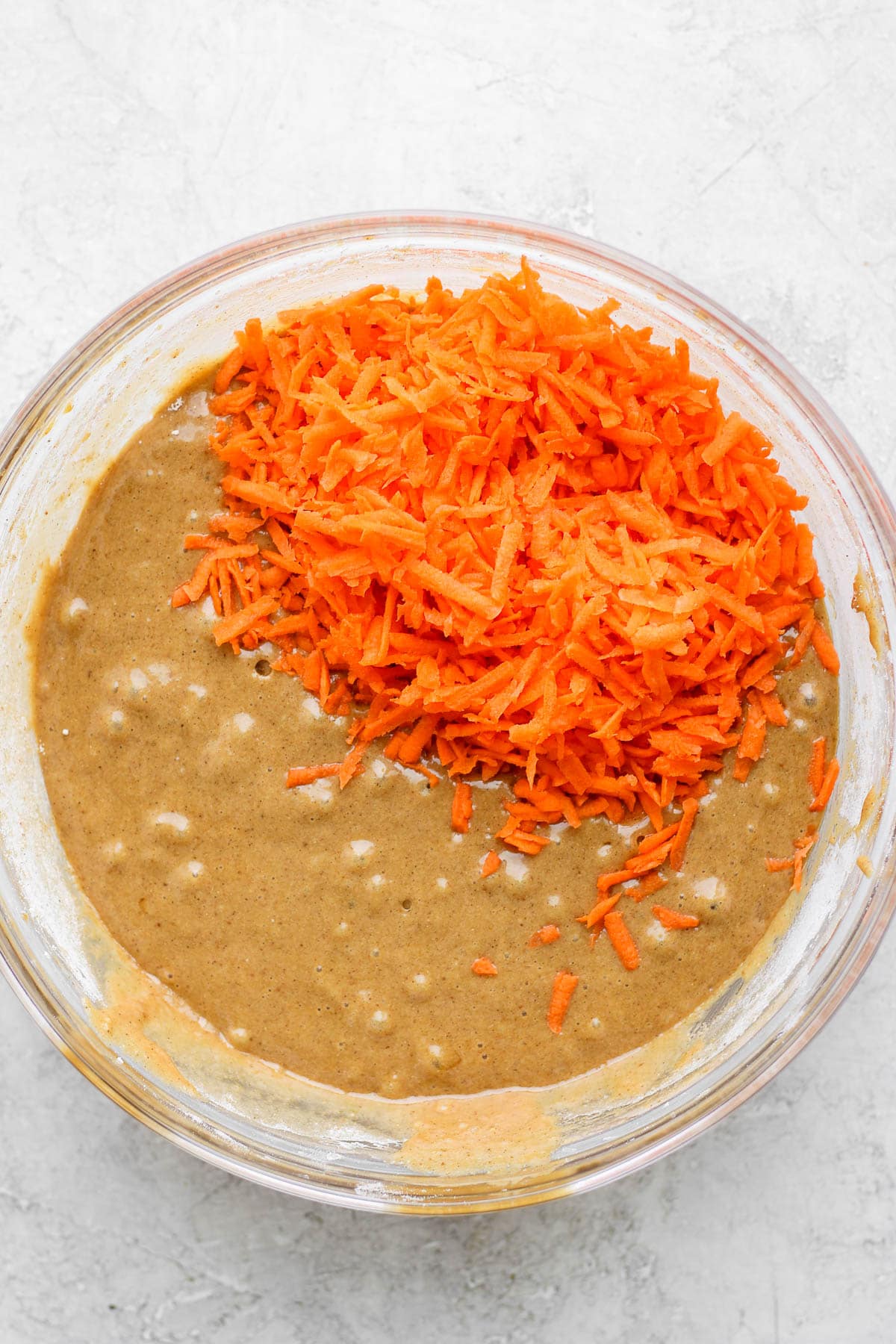 Grated carrot added to gluten free carrot cake batter.