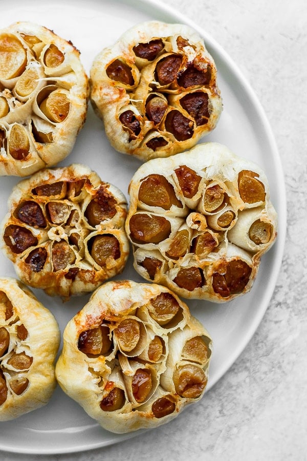 Roasted garlic heads on a plate.