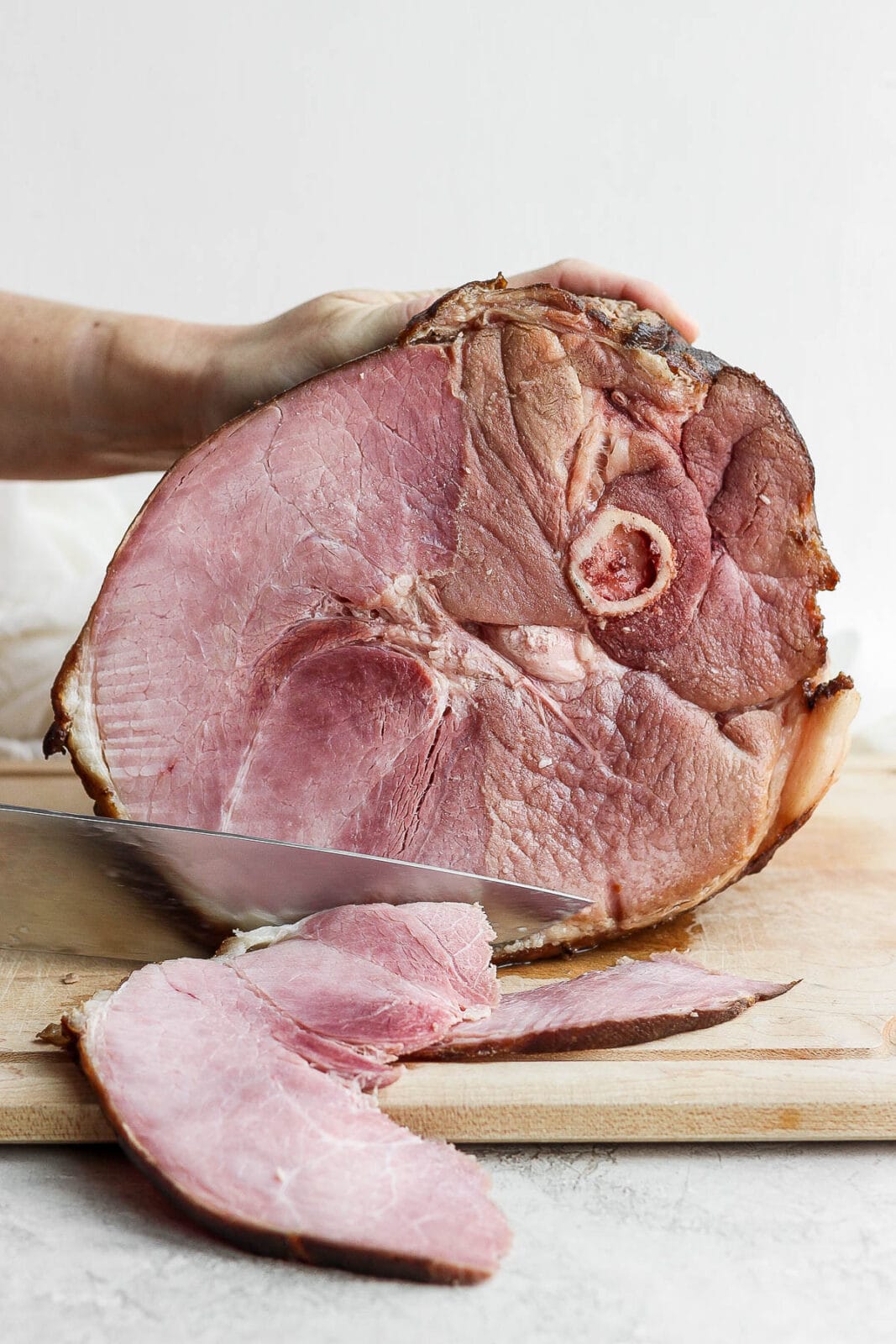 Ham being carved on a cutting board.