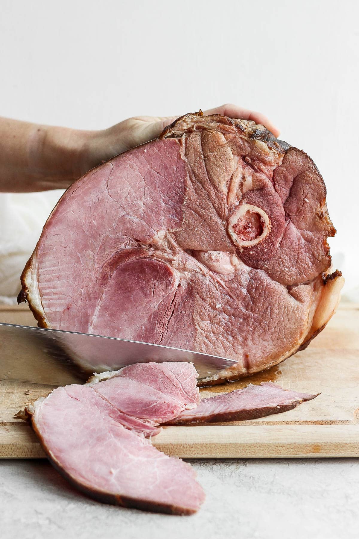 Ham being carved on a cutting board.