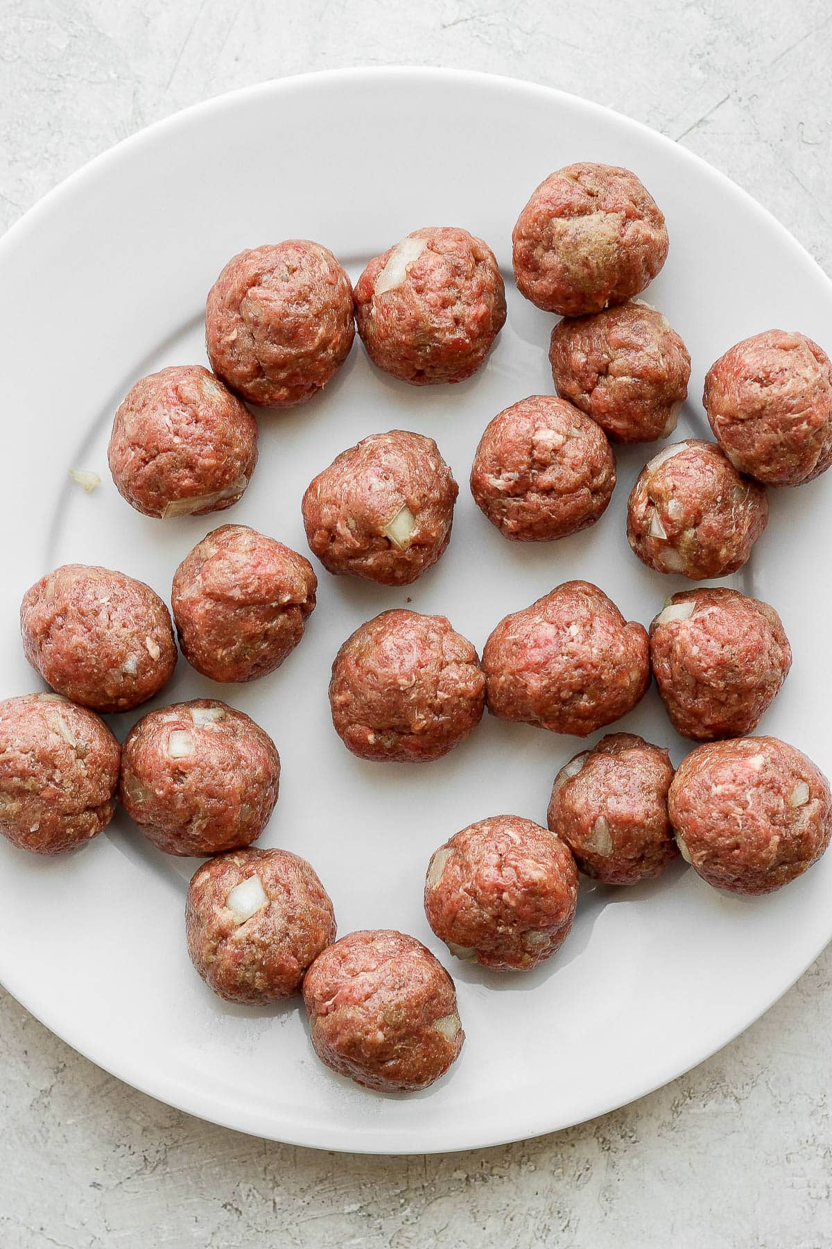 Plate of rolled meatballs before cooking.
