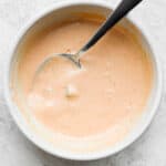 Bowl of homemade burger sauce with a spoon sticking out.