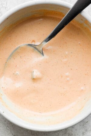 Bowl of homemade burger sauce with a spoon sticking out.