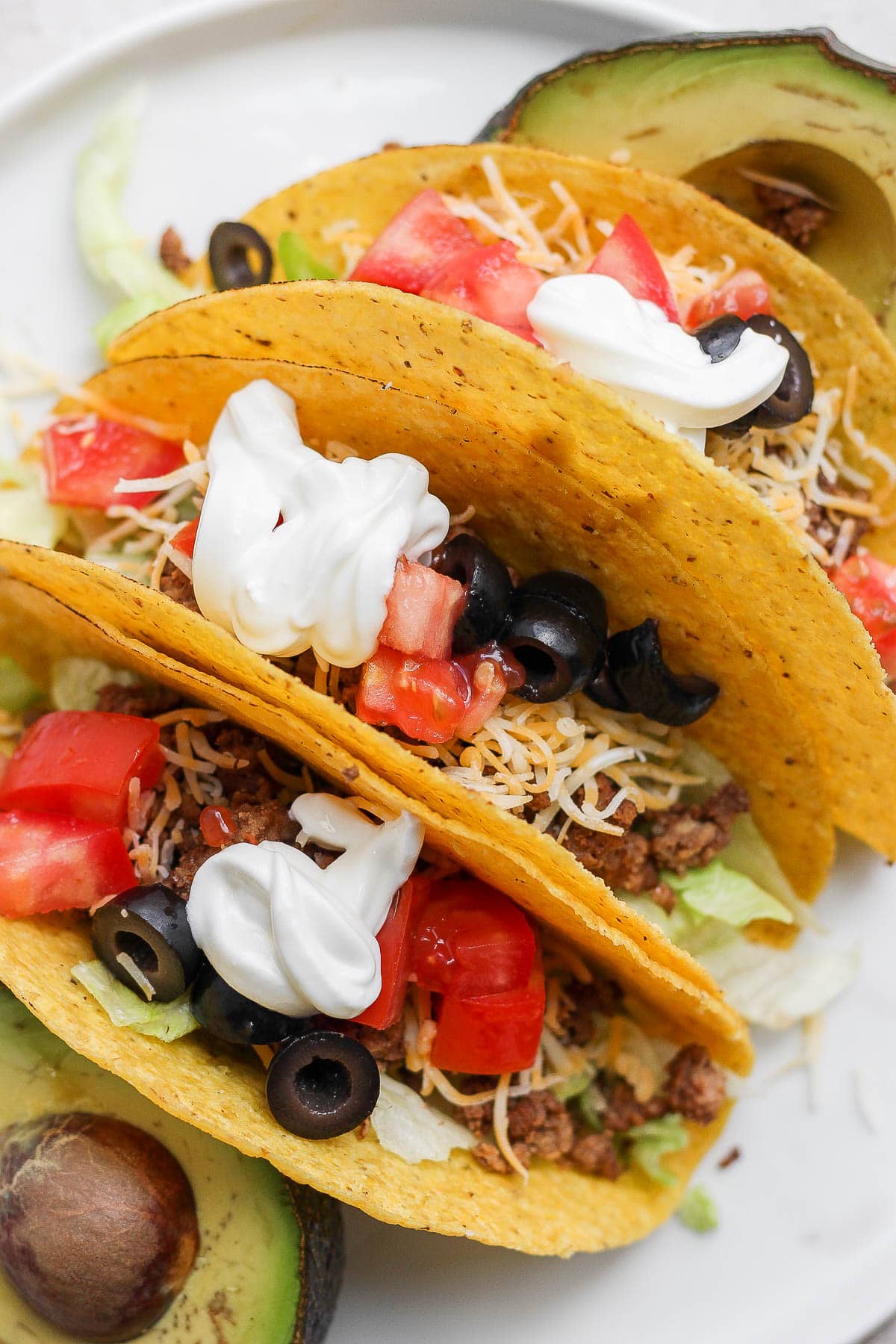 Plate with 3 homemade tacos in hard shells.