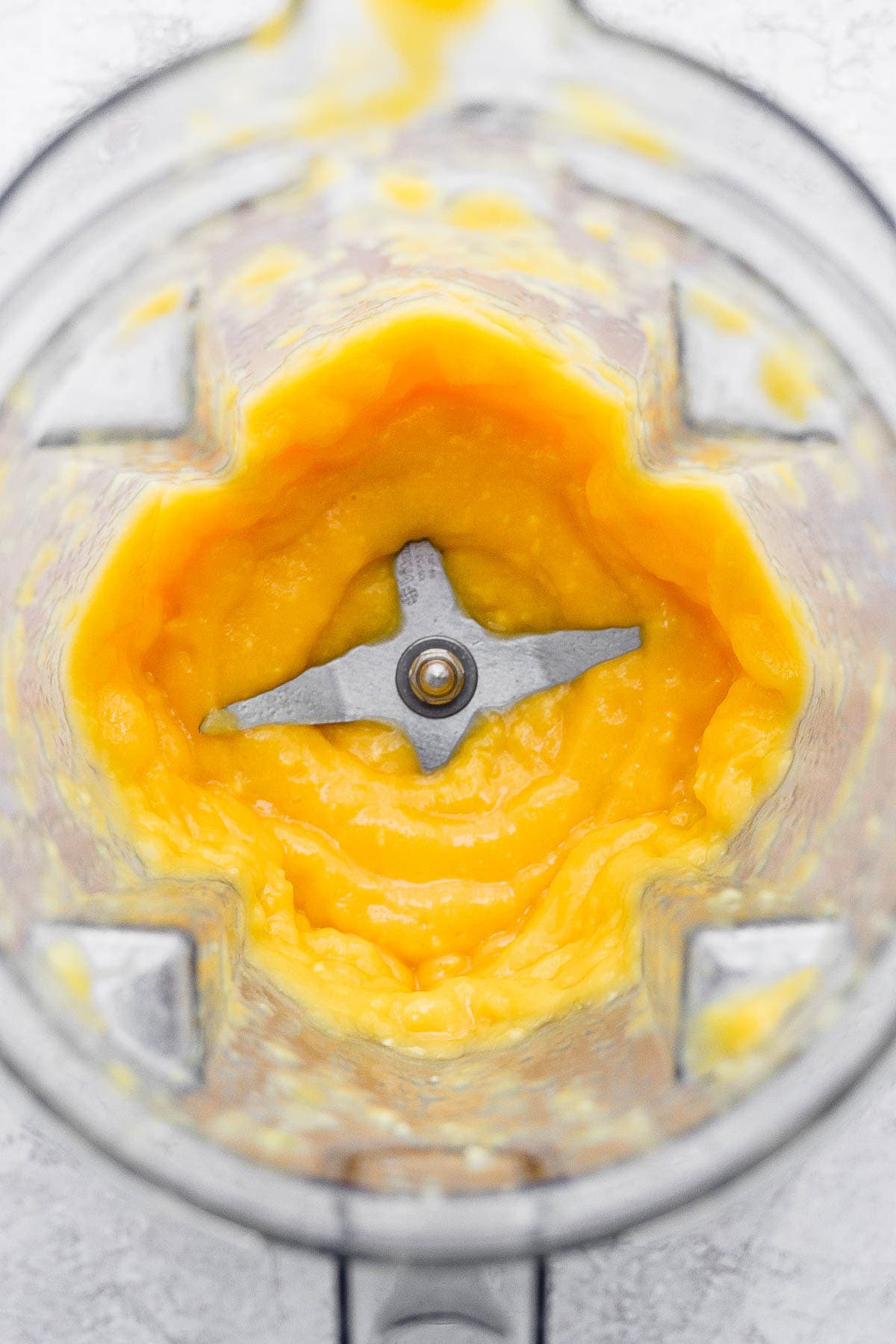 A blended mango margarita in a blender. 