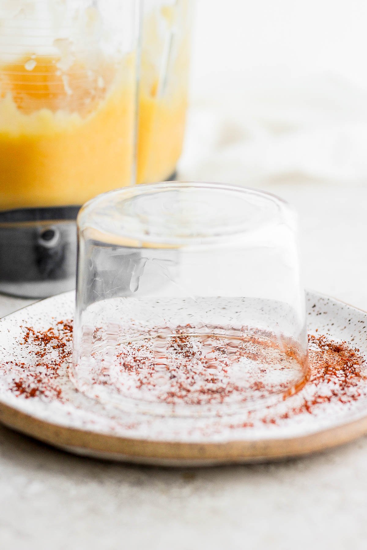 A glass upside down in a chili lime rim mixture. 