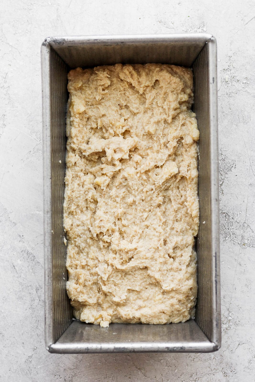 Paleo banana bread batter in a greased loaf pan.