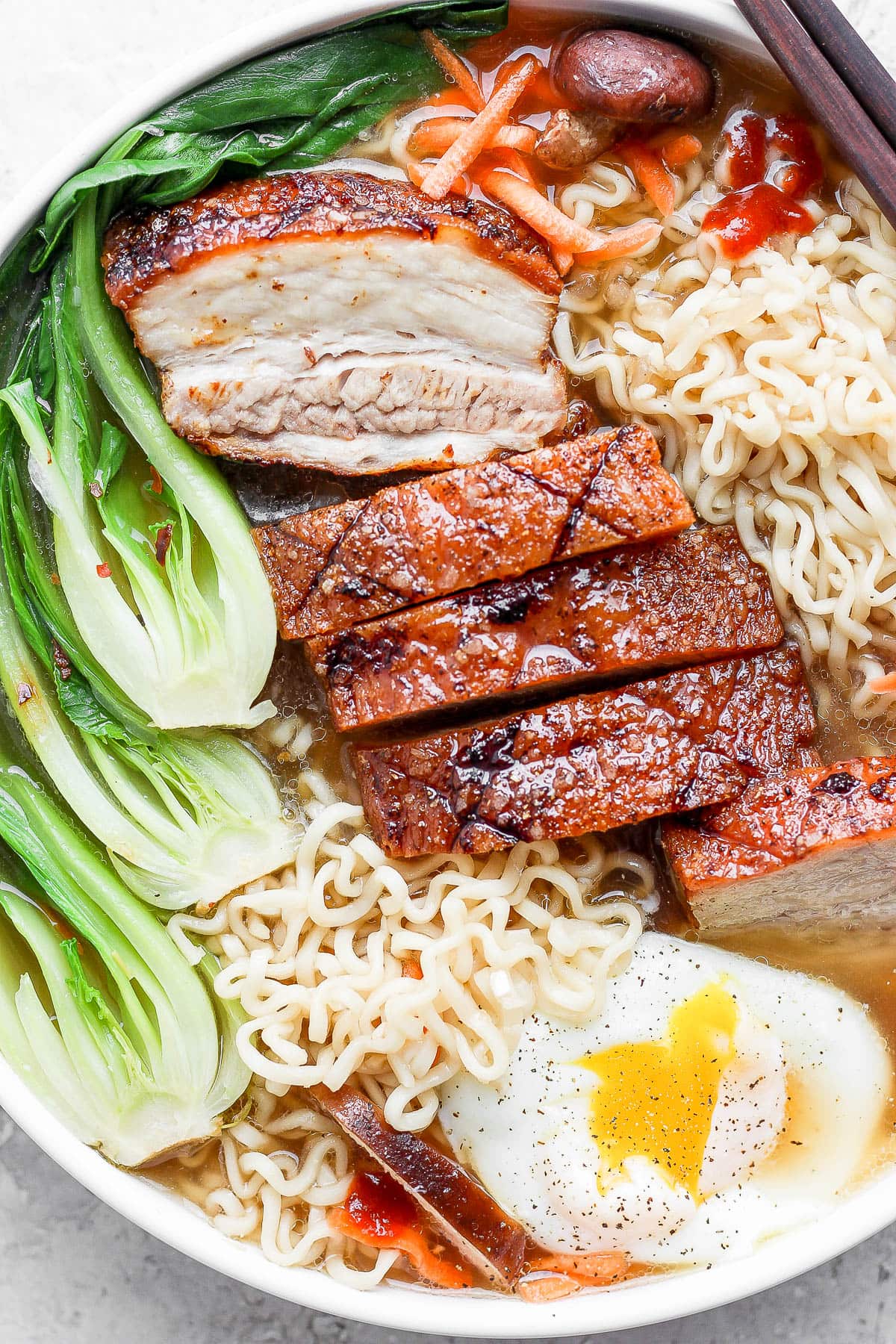 Pork belly ramen in a bowl with chopsticks.