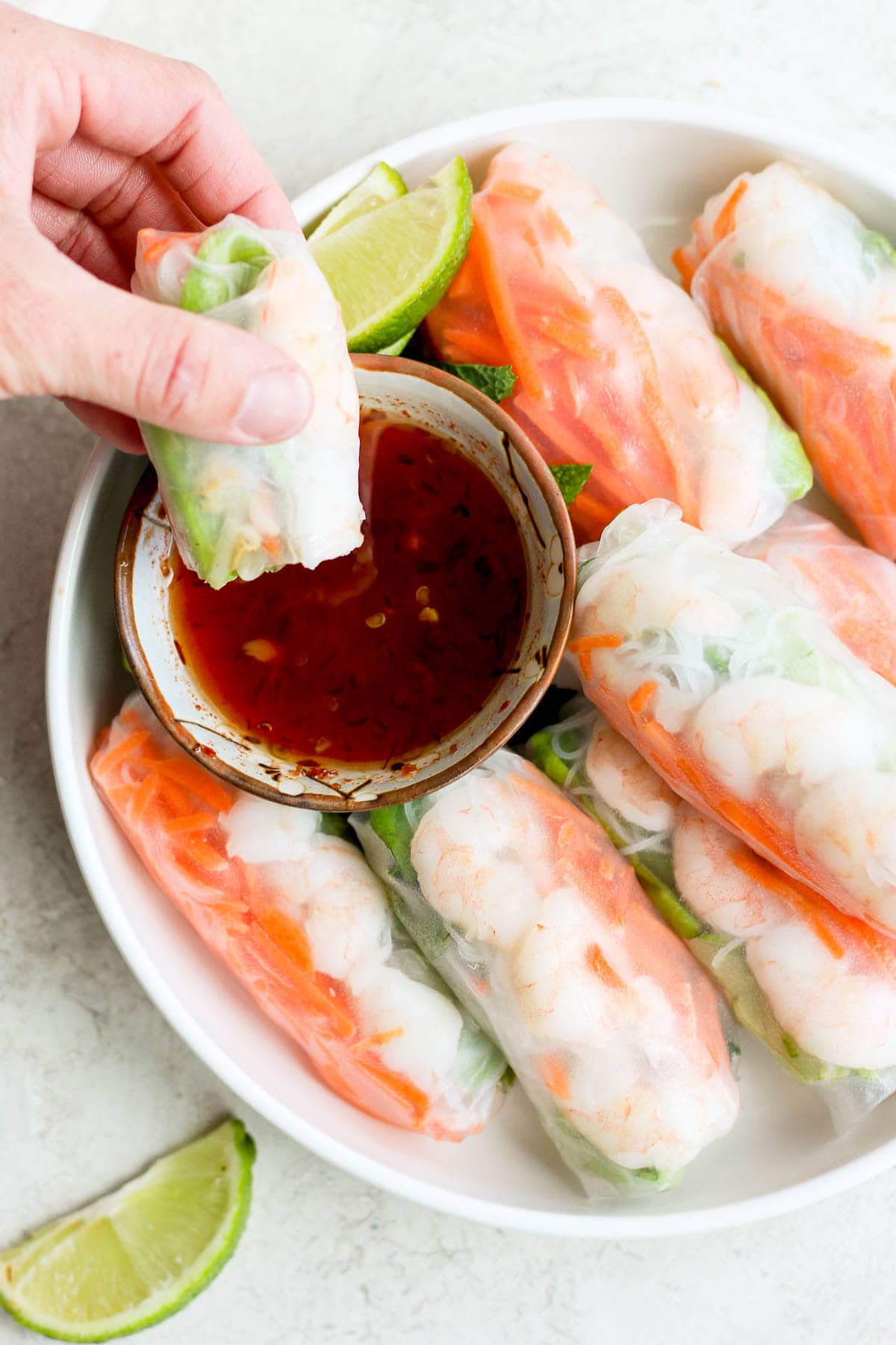 A spring roll being dipped into the dipping sauce.