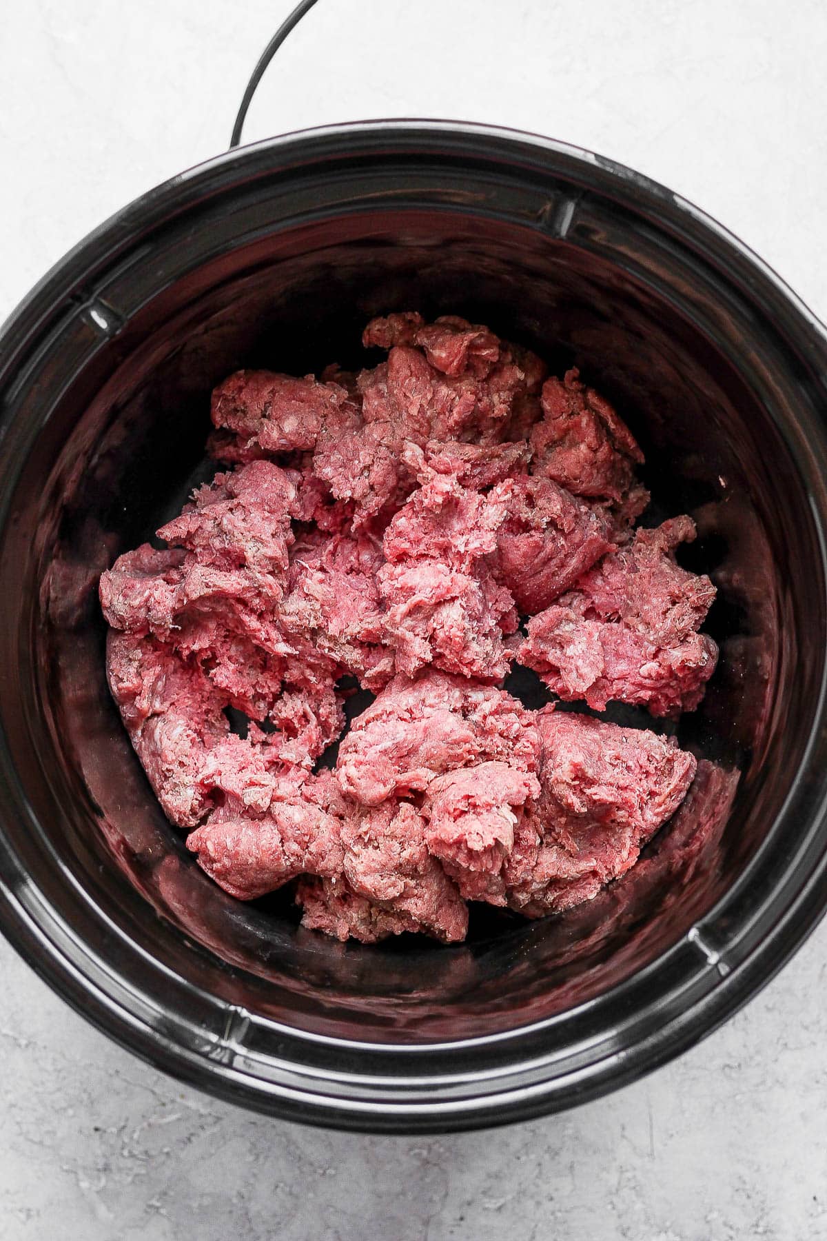 Crockpot with raw ground beef.