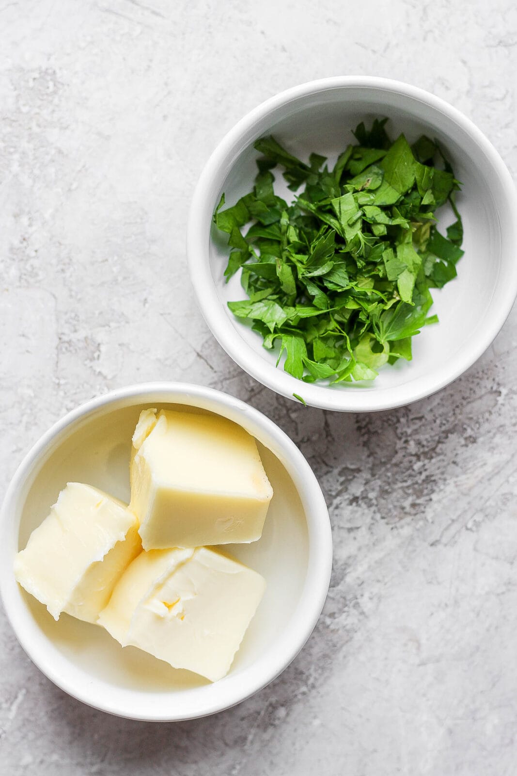 Ingredients for herbed butter in bowls.
