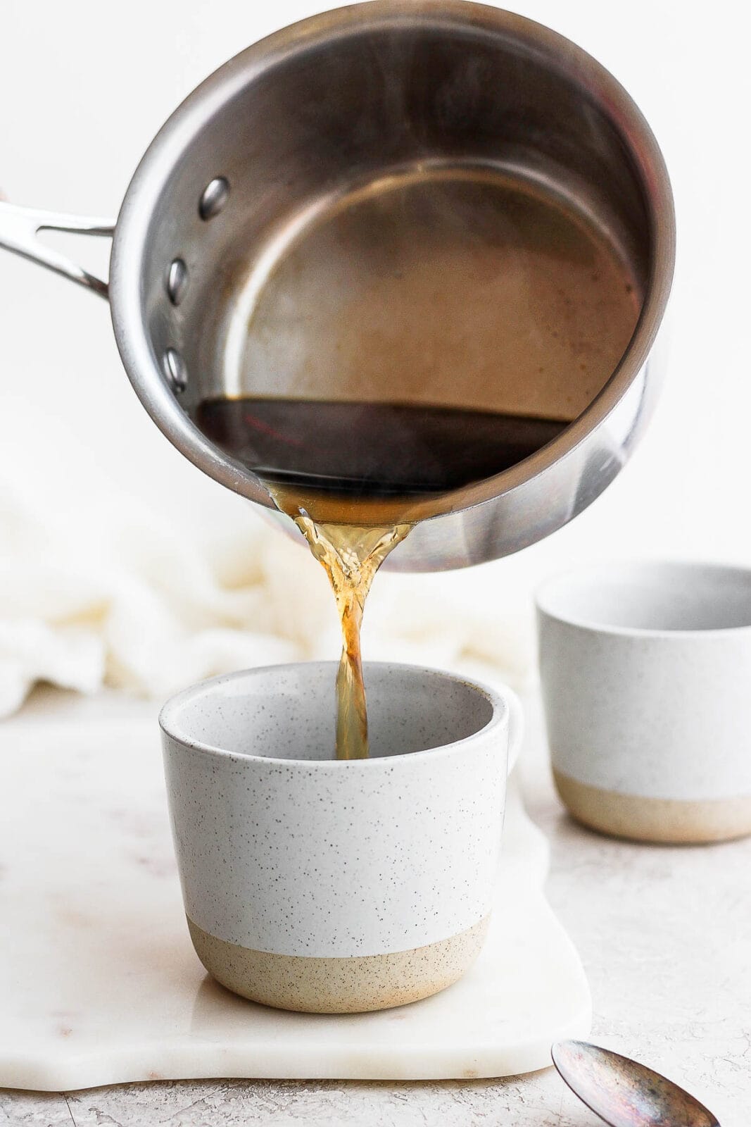 Earl Grey tea being poured into a mug. 