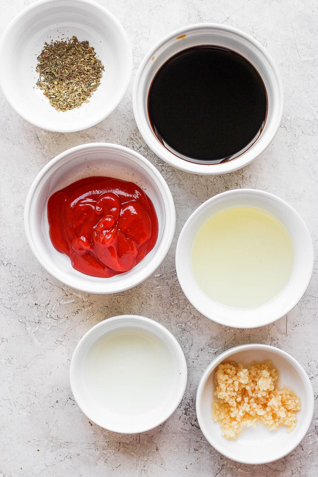 Ingredients for a pork tenderloin marinade in separate bowls. 