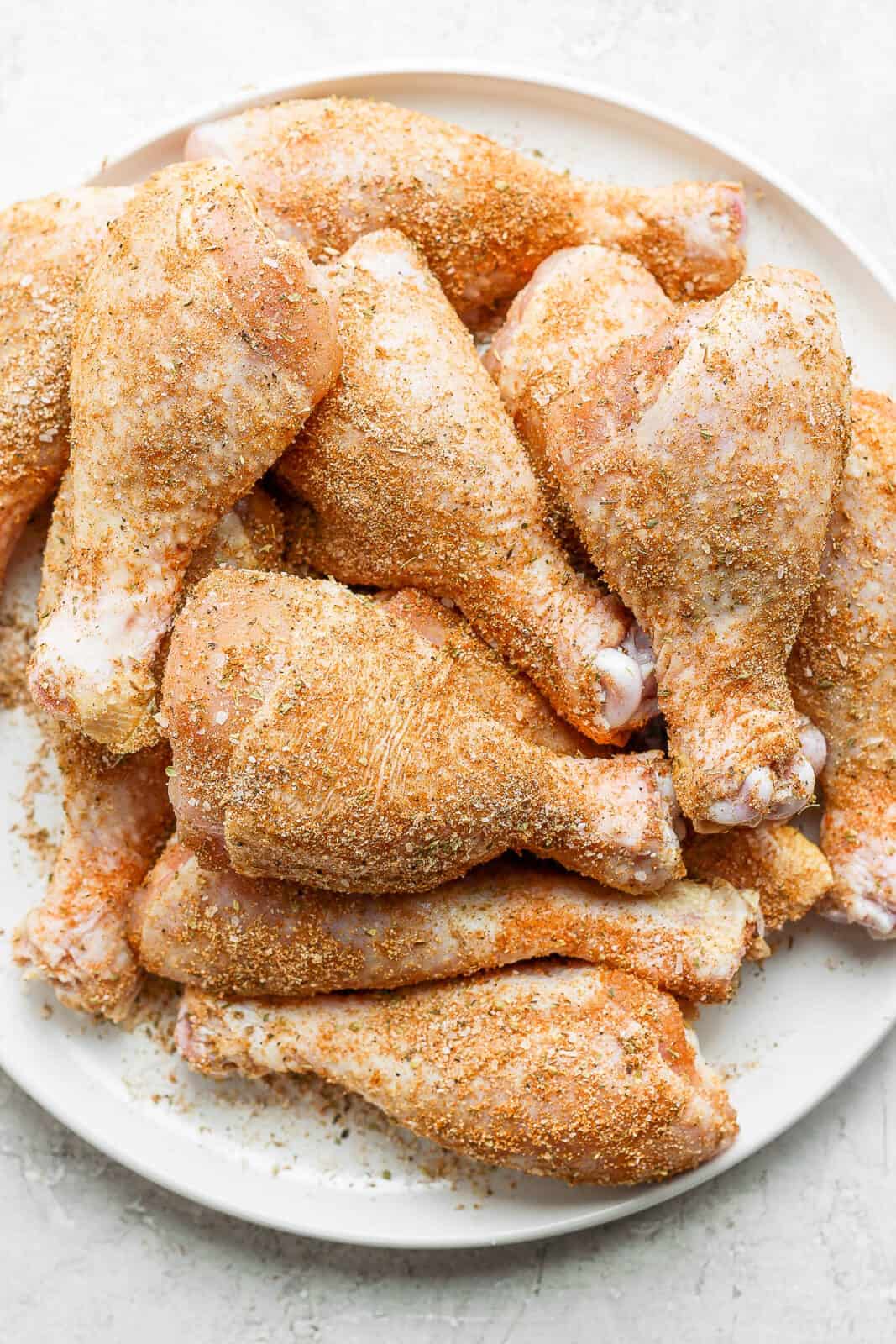 A plate of chicken legs covered in dry rub. 