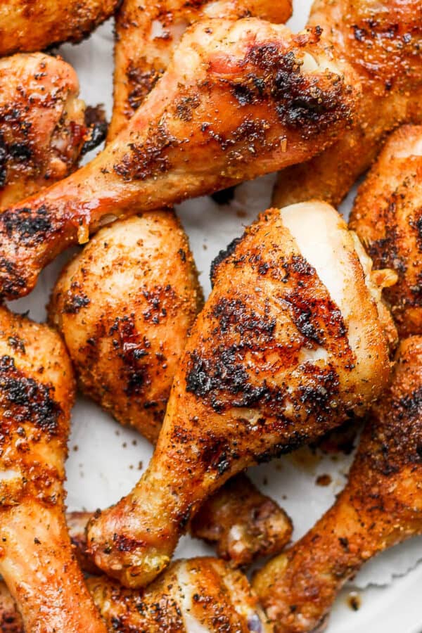 Several smoked chicken legs piled on a large plate.