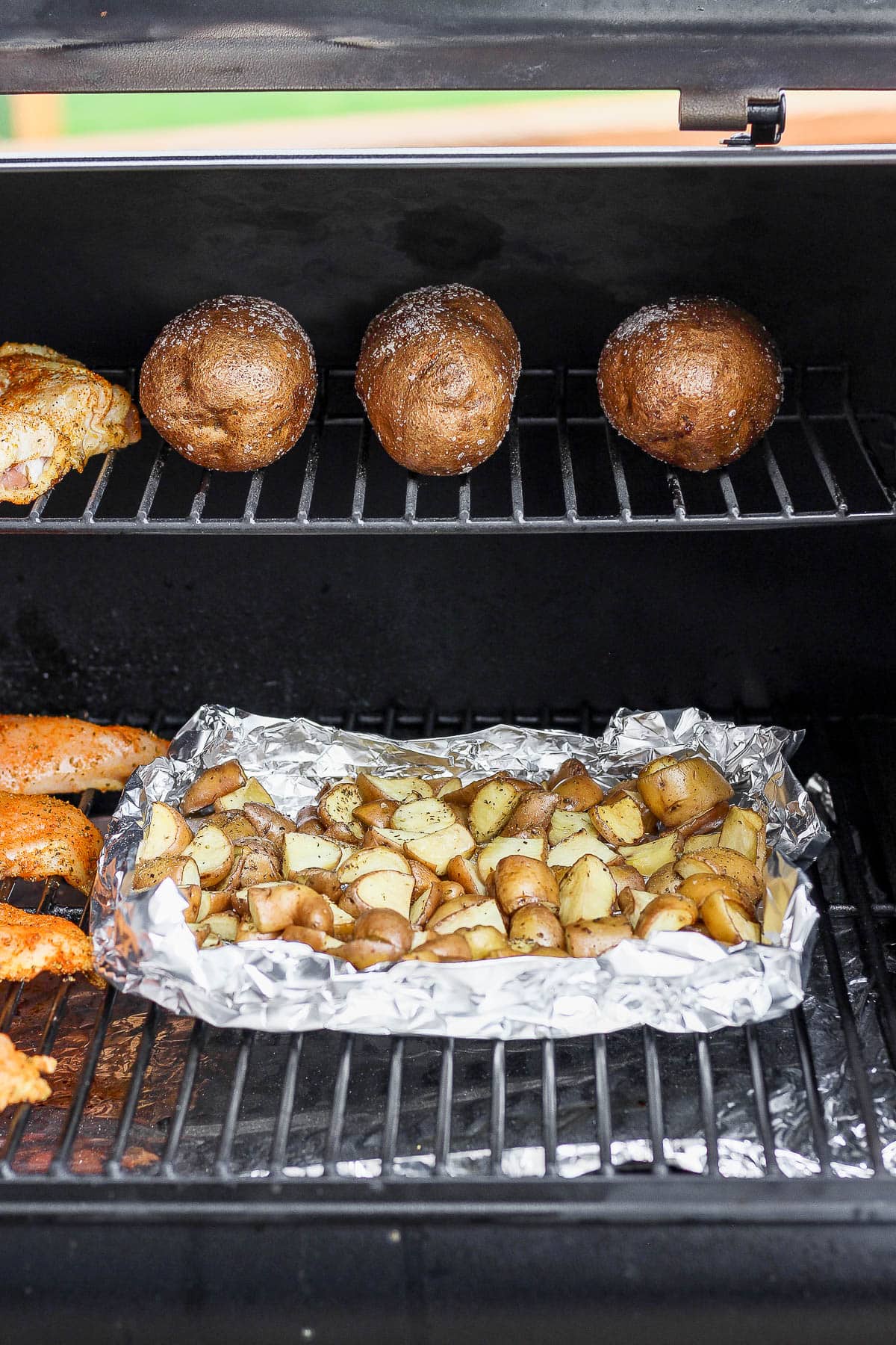 Cubed and whole potatoes on a smoker.