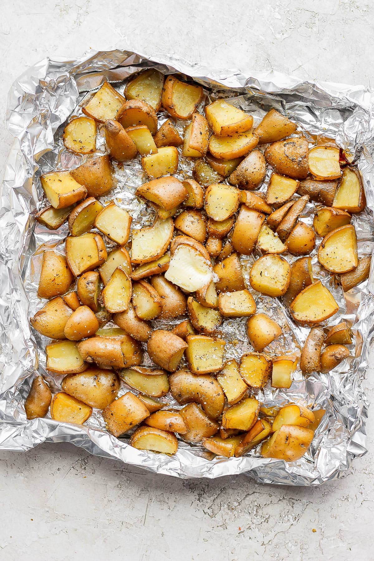 Smoked potatoes in an aluminum foil boat.
