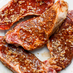 Four steaks covered in the best steak marinade.