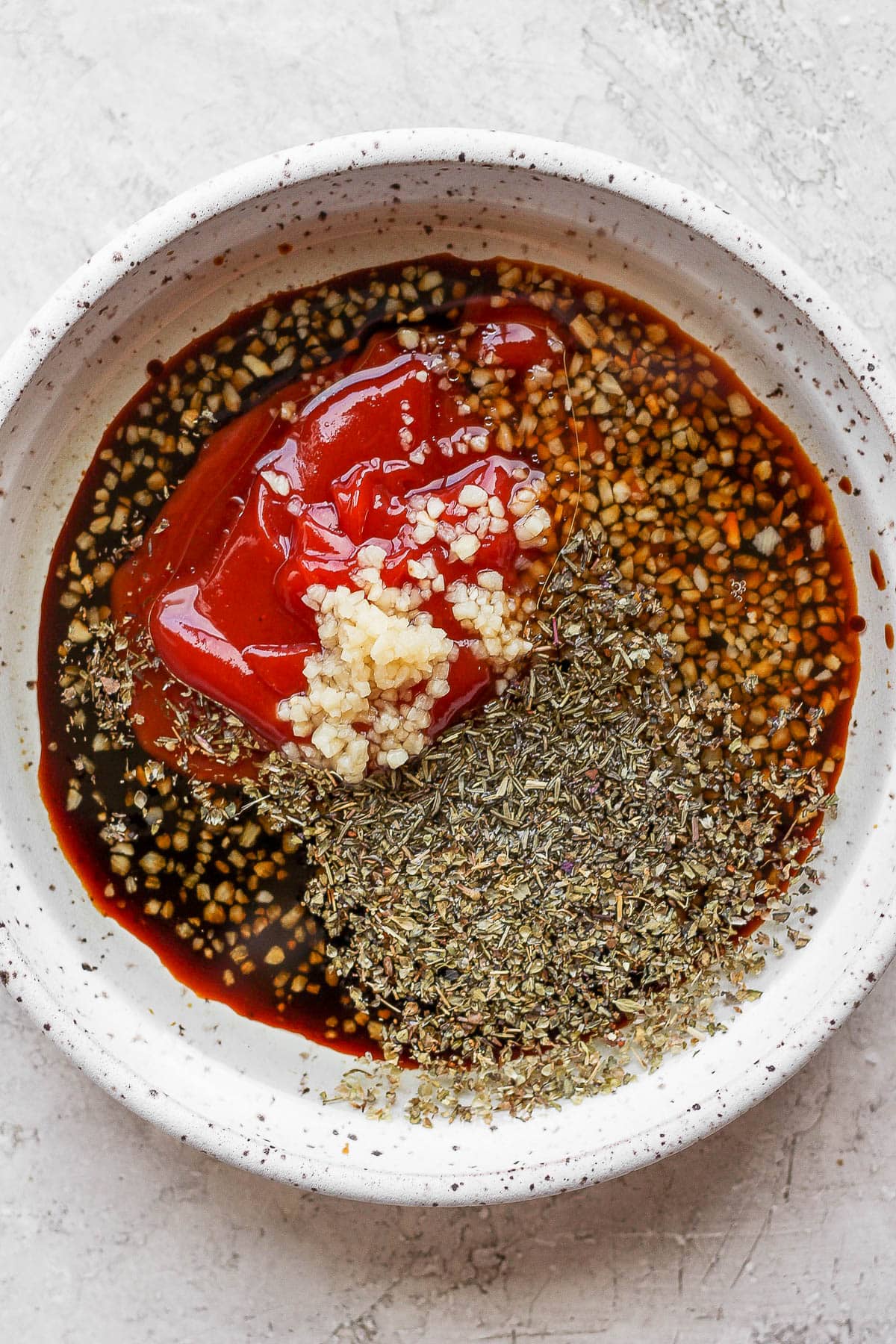 Ingredients for a steak marinade in separate white bowls. 