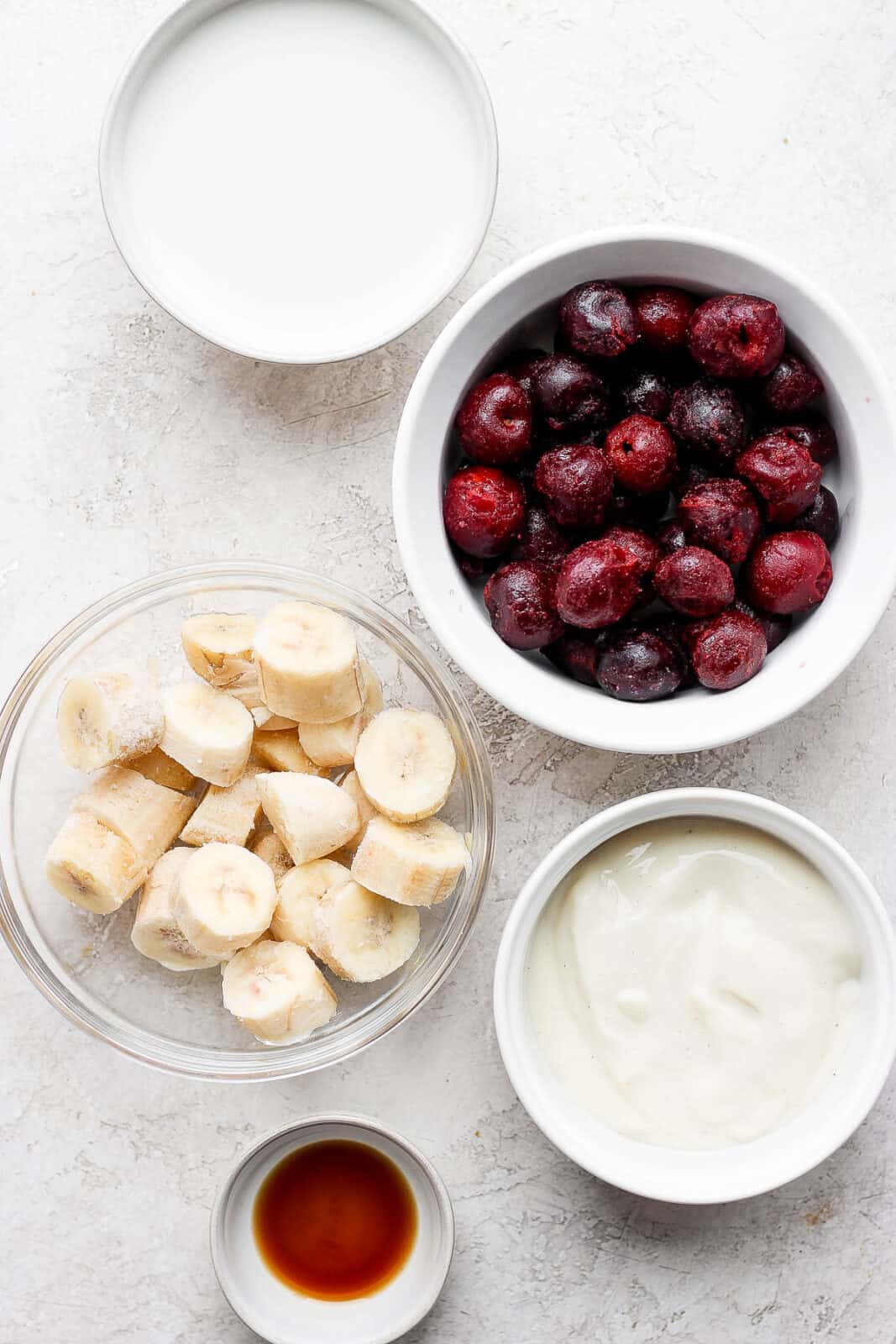 Cherry smoothie ingredients in separate dishes.