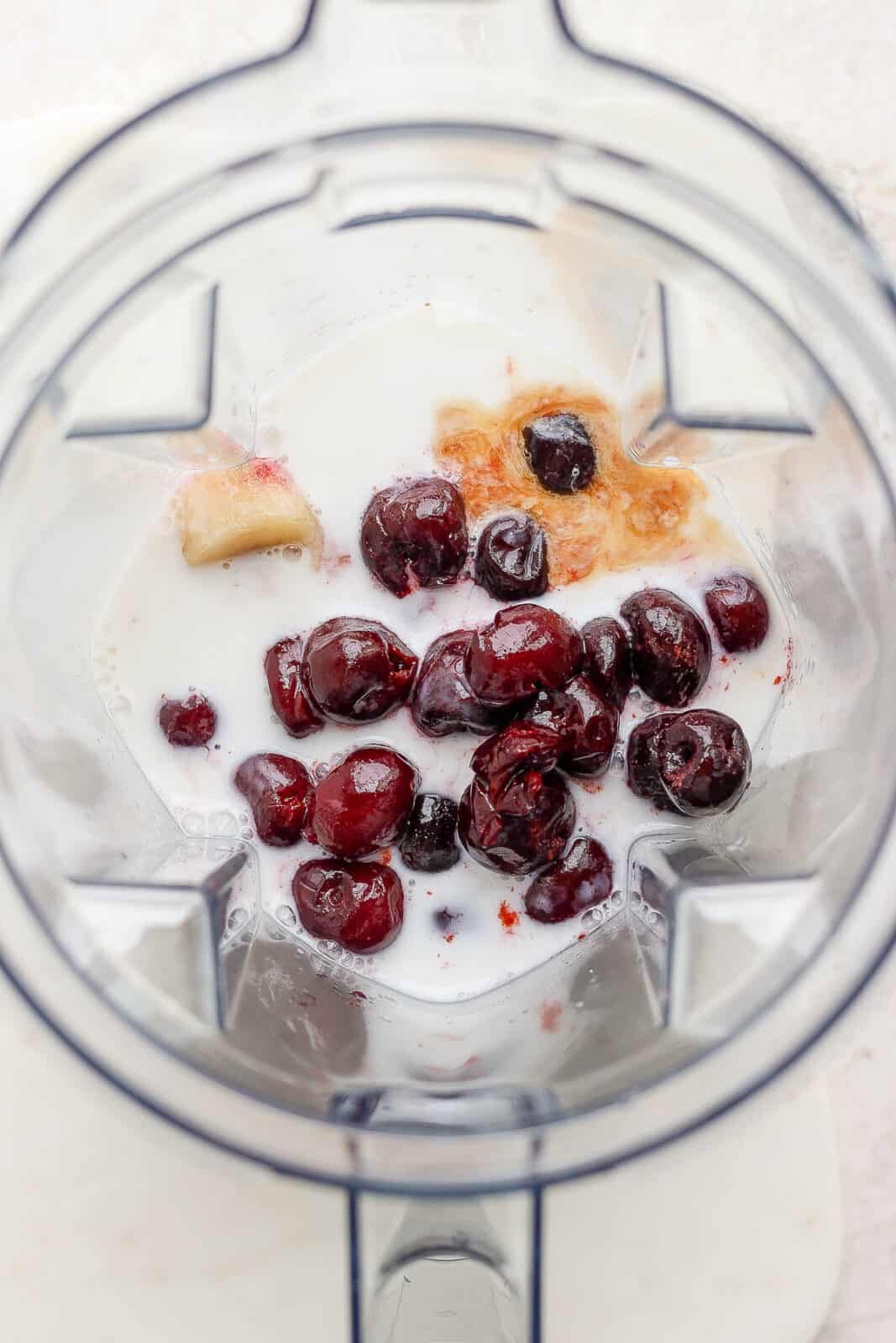 Cherry smoothie ingredients in a blender.