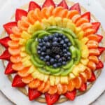 Fruit pizza on a while marble board.