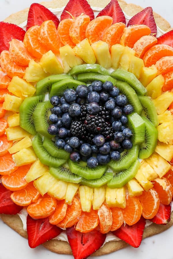 Fruit pizza on a while marble board.