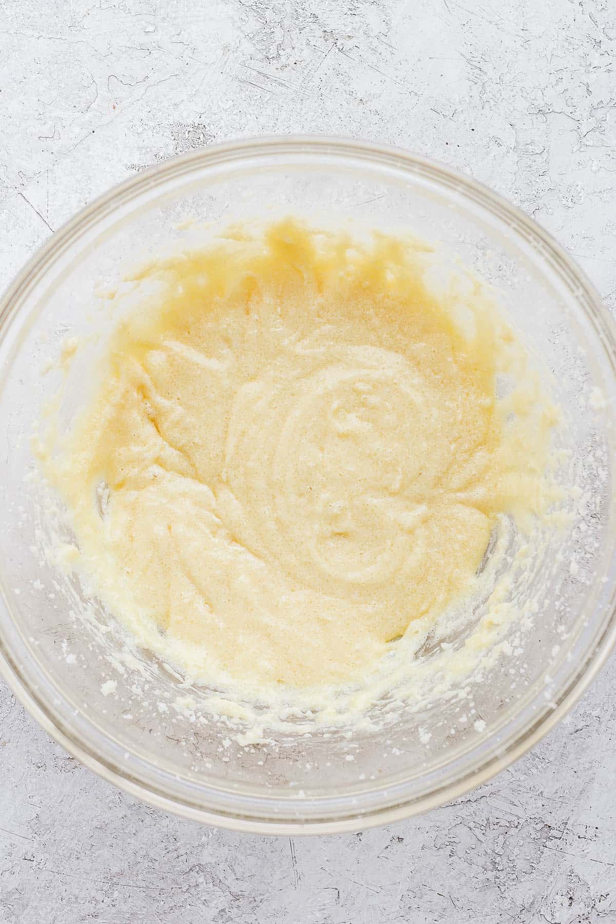 Sugar, butter and egg mixed together in a bowl. 