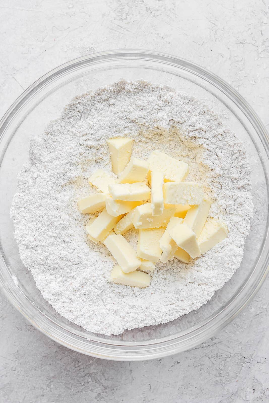 Bowl of dry ingredients and cold butter on top. 