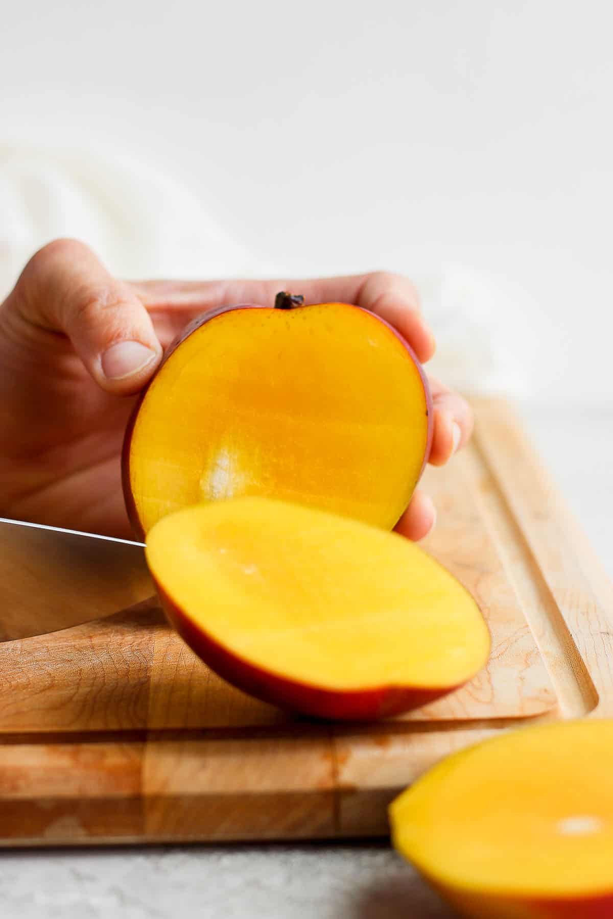 A mango with the front half sliced off.