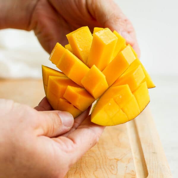 Someone showing a cubed mango.