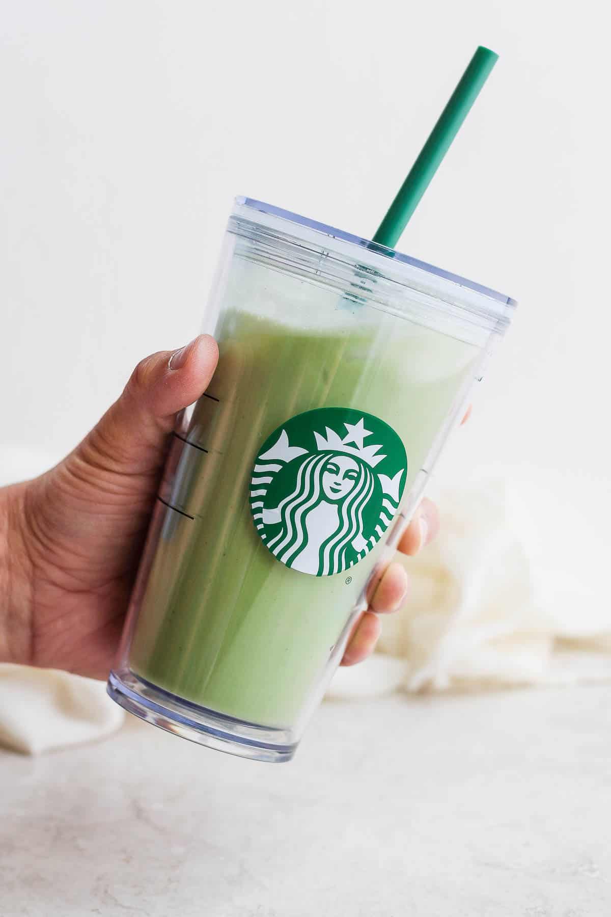 A Starbucks reusable to-go cup with an iced matcha latte inside. 